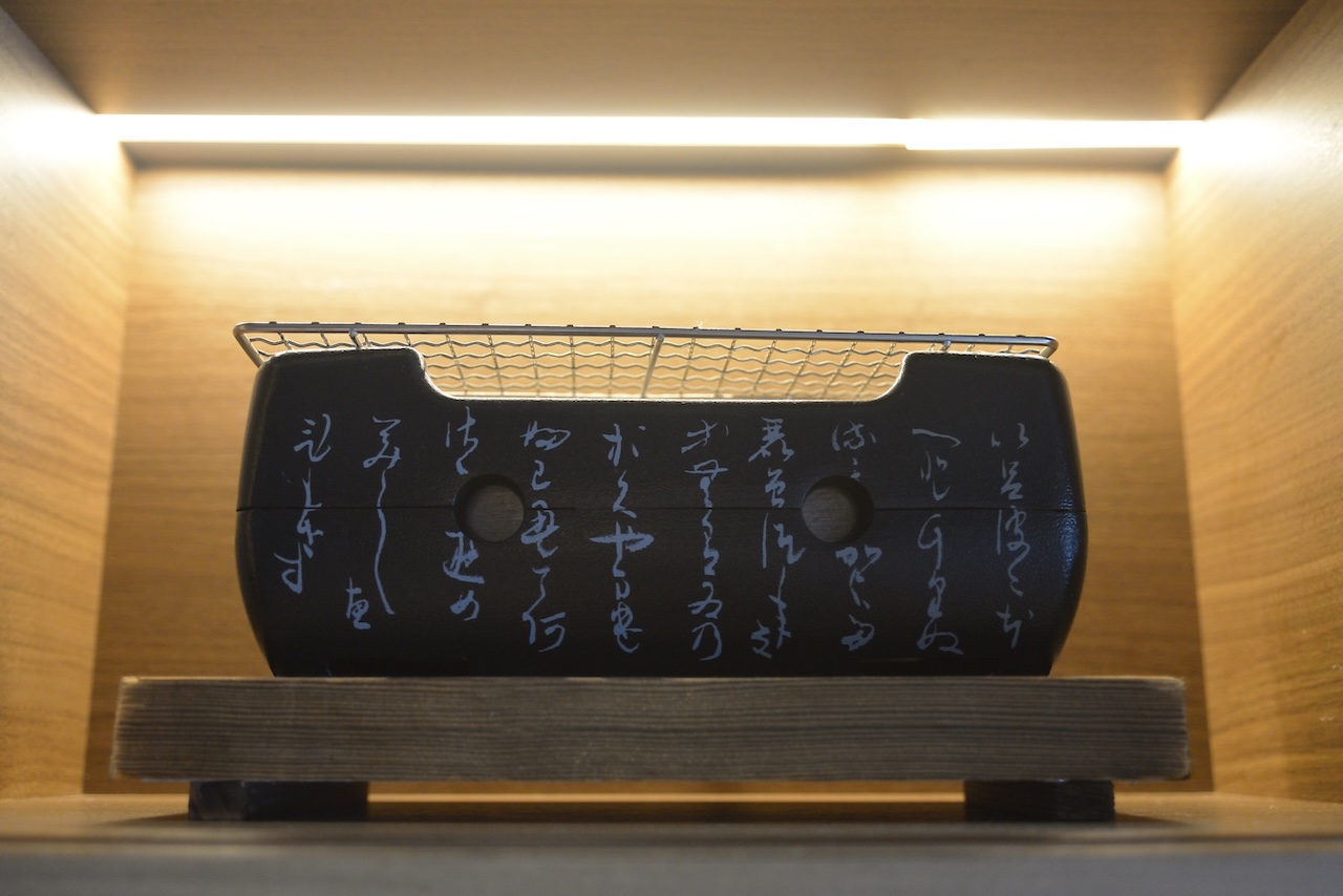 飾り棚に置かれた書入りの炭火コンロ