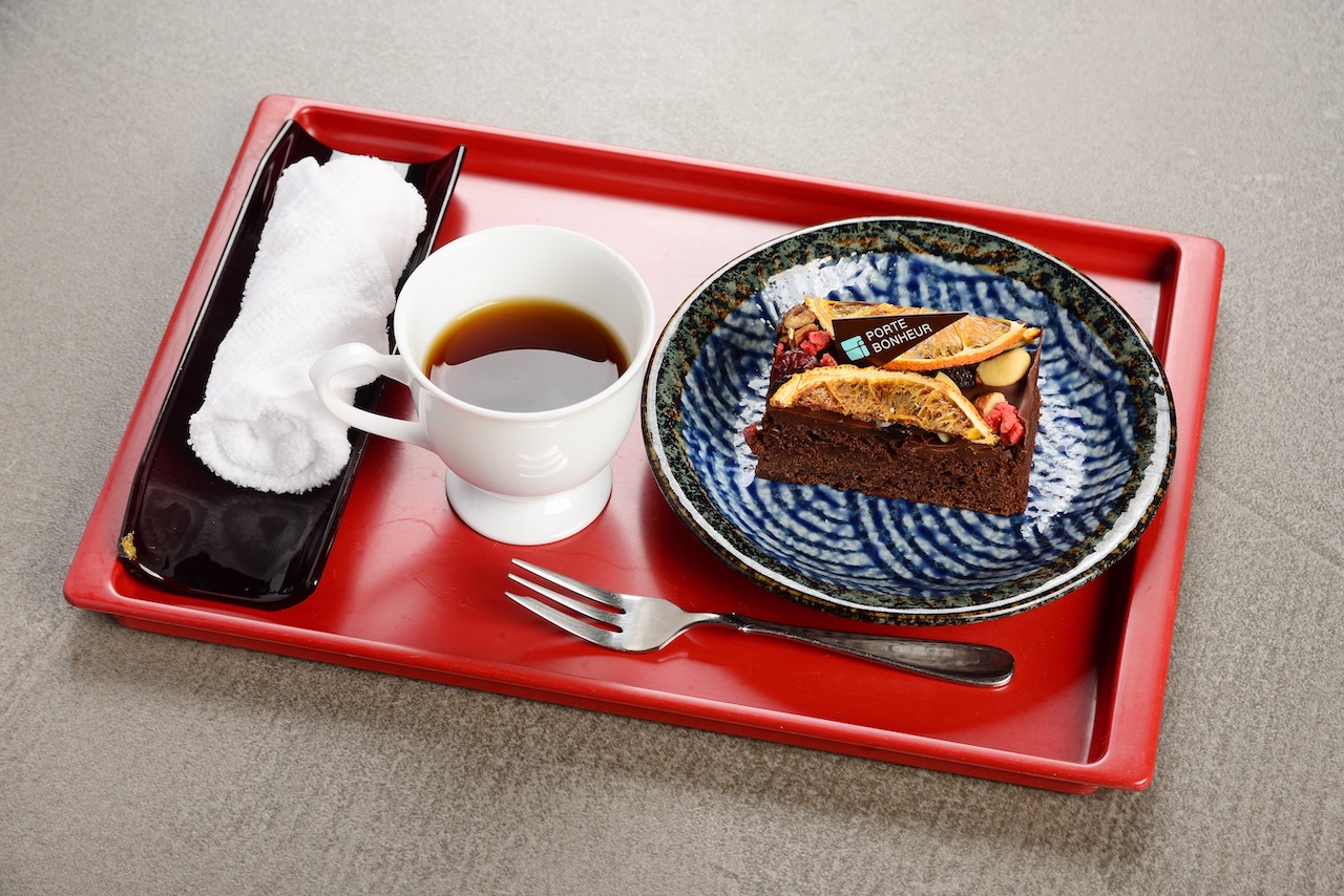 赤いトレーにのせたガトーショコラとコーヒー
