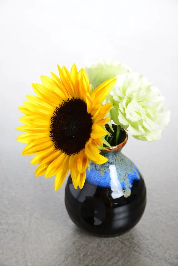 黄色のひまわりとグリーンの花 黒と藍の花瓶