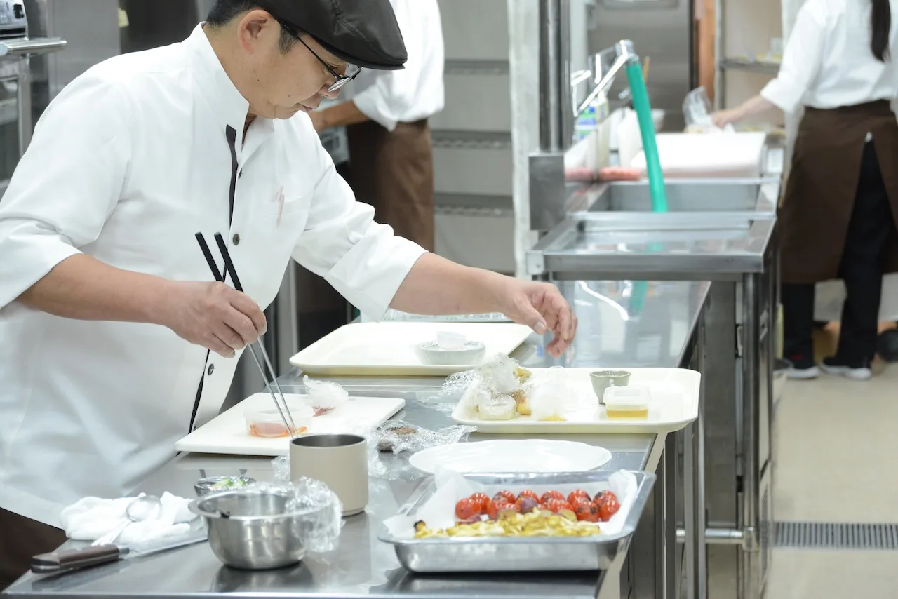 厨房で盛り付けをする料理長