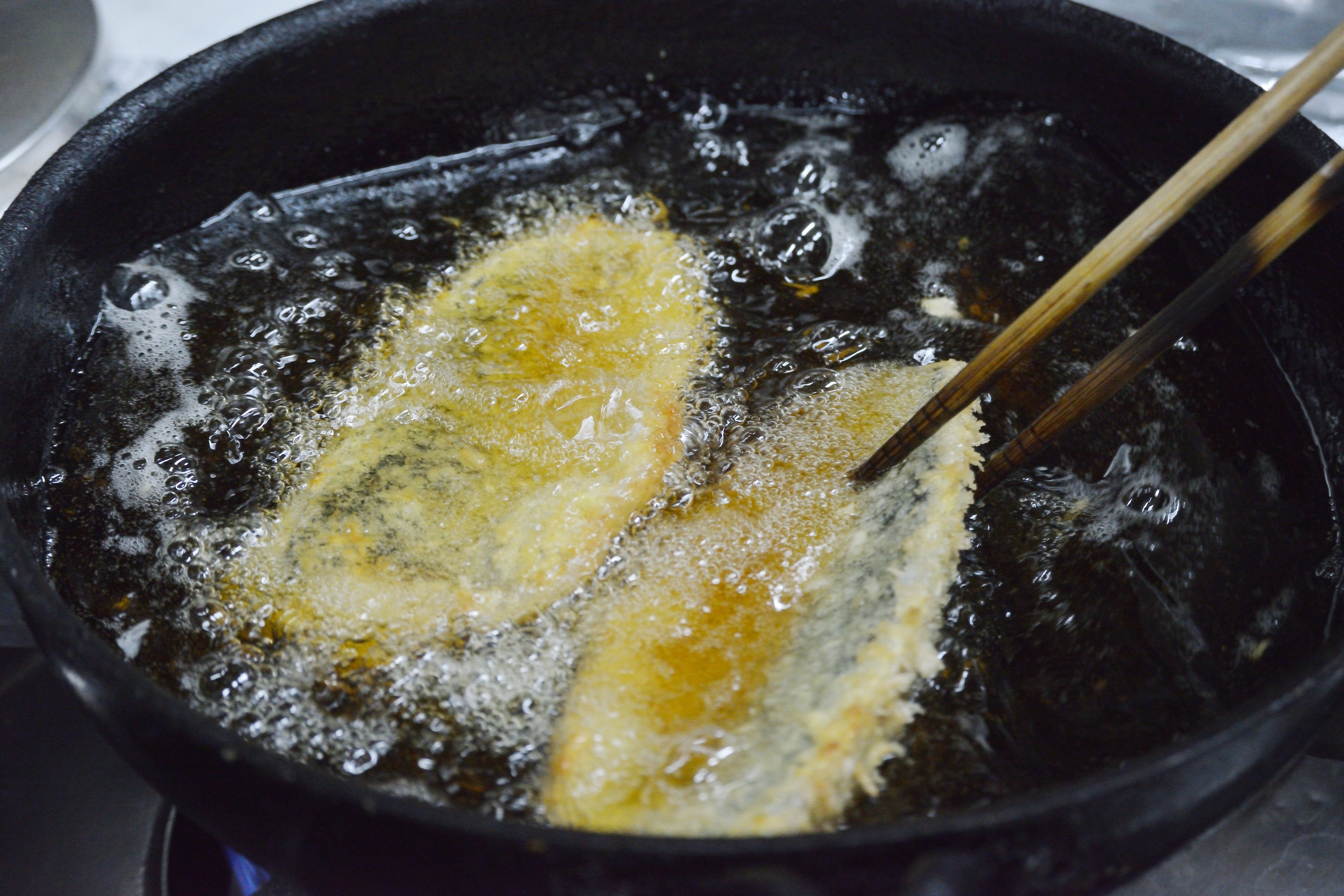 きつね色に揚がっていく魚のフライ