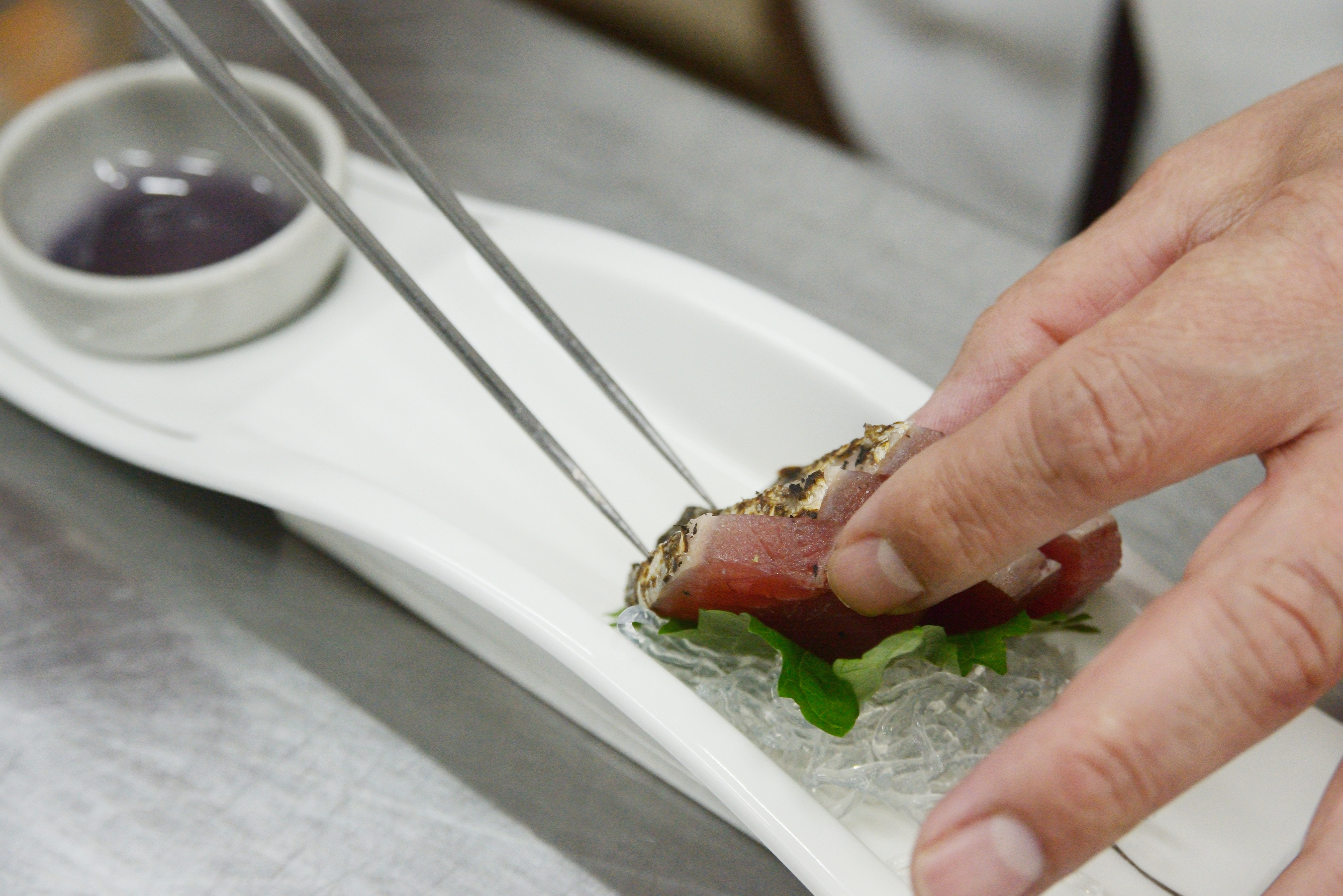 香ばしく炙った魚を盛り付ける手元