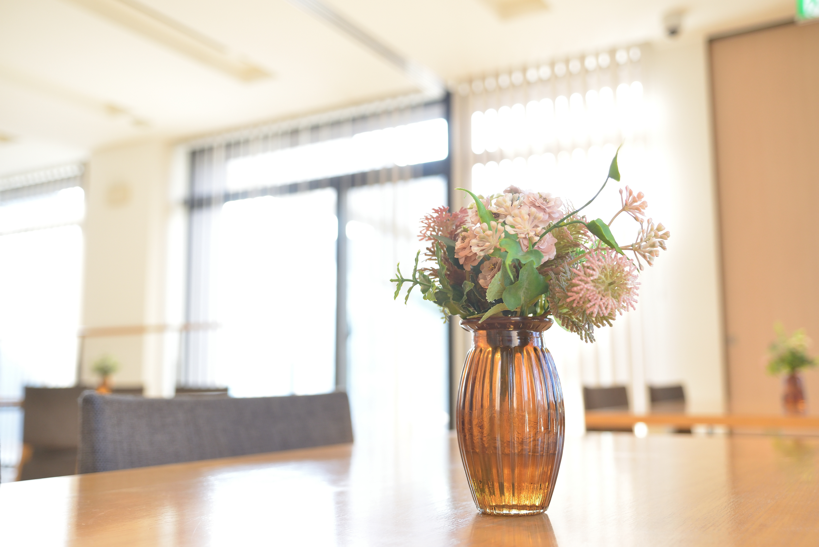 テーブルの琥珀色の花瓶に生けた秋の小花