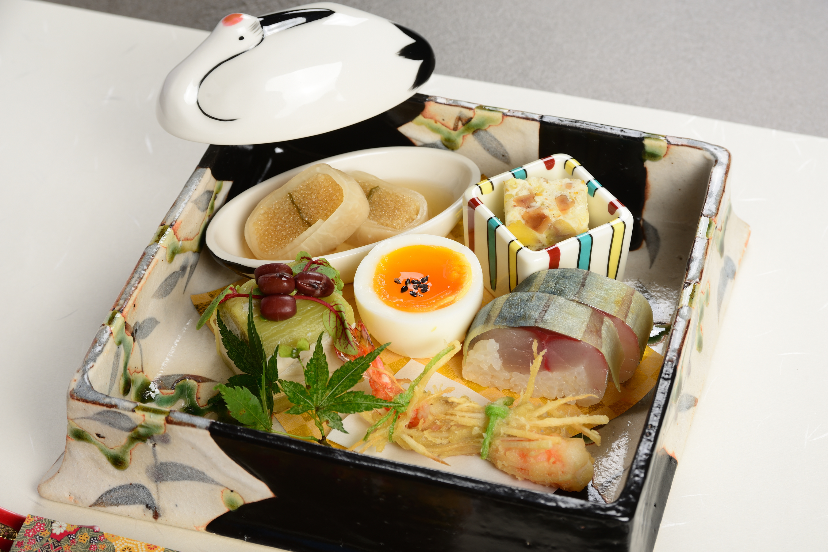 前菜の角箱のアップ 幸福玉子と鯖小袖寿司